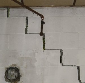cracks in white cinderblock wall